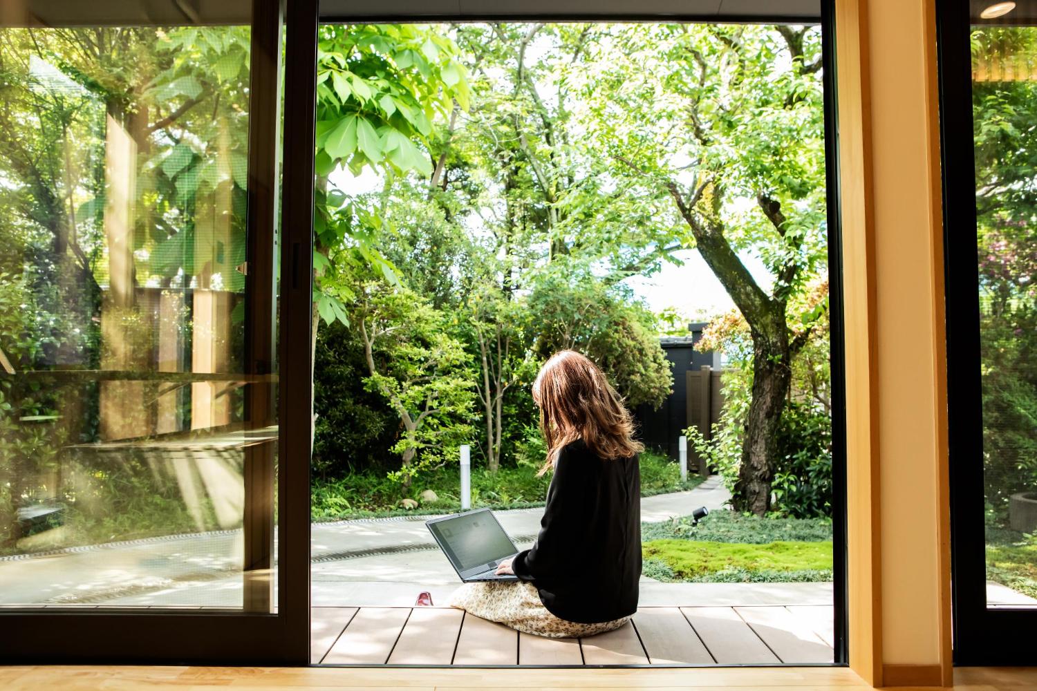 Female guest working on the porch of the guesthouse where she stayed during her trip to Japan.